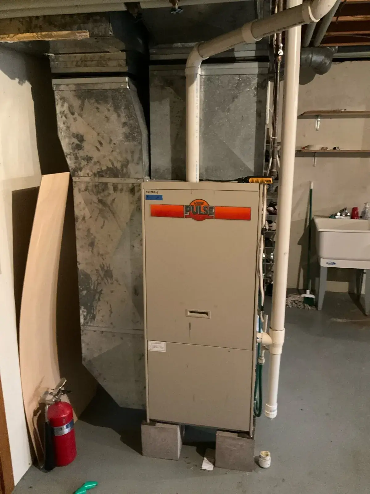 Before — the same aging furnace and duct trunk before removal