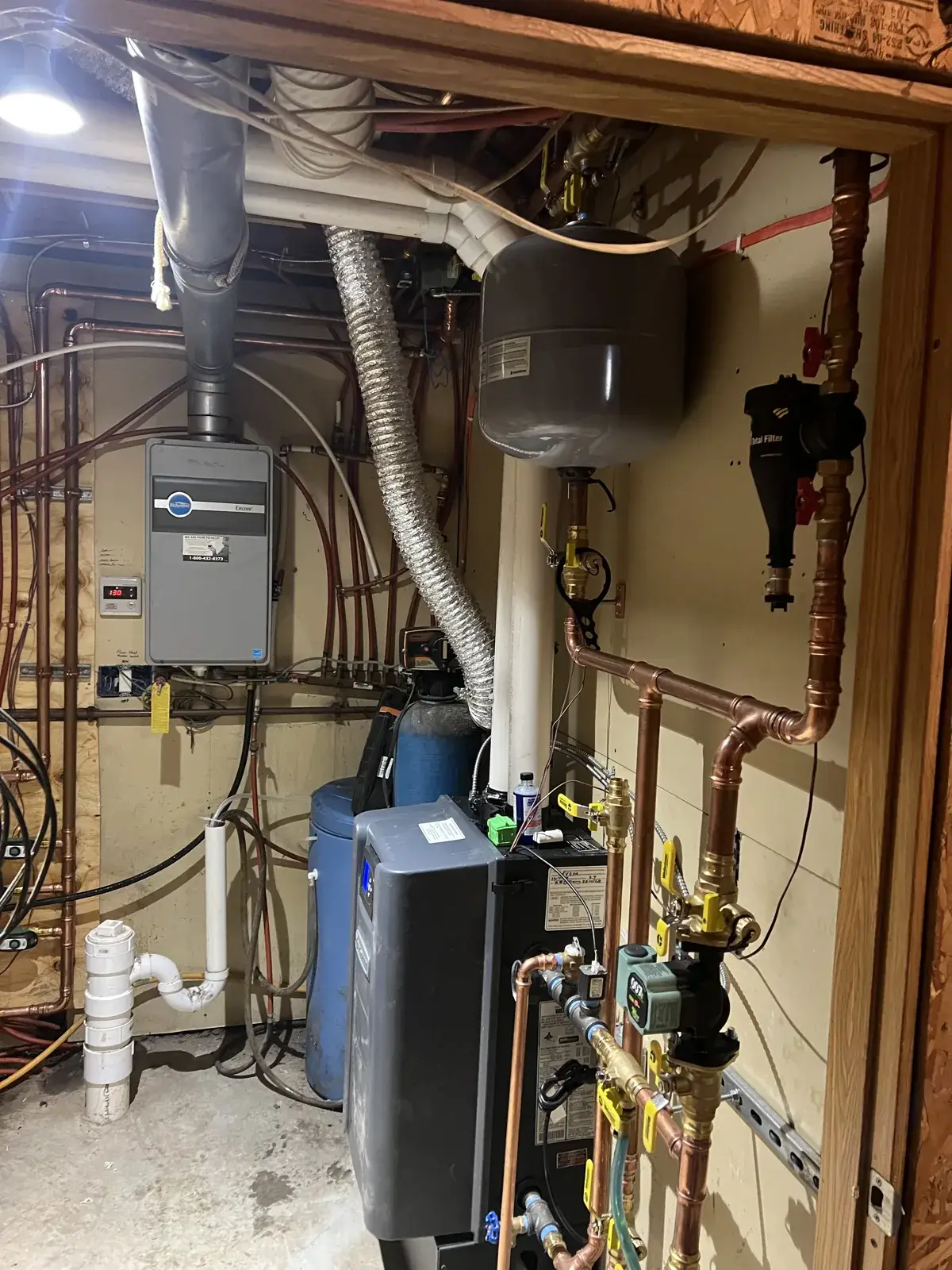 The finished mechanical room — boiler, expansion tank, circulator and copper near-boiler piping all labeled and run clean