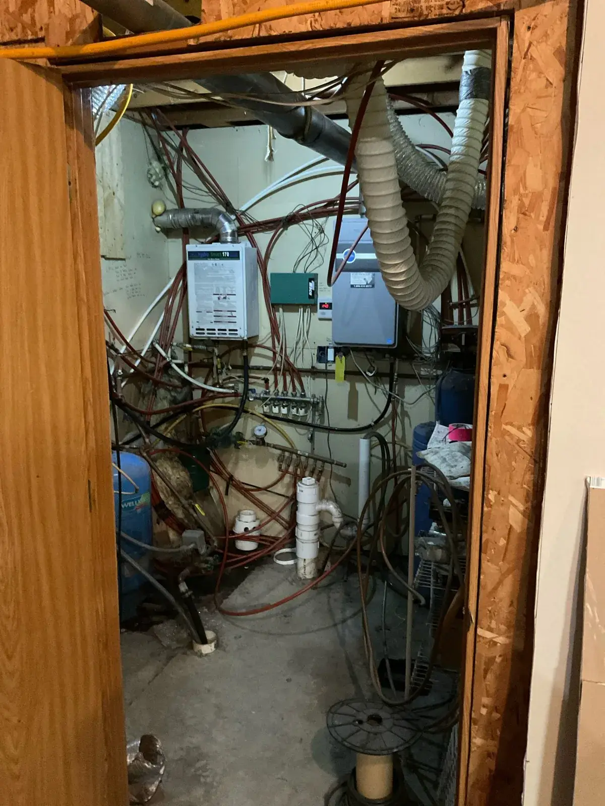 Before — the whole utility room as we found it, lines run every direction