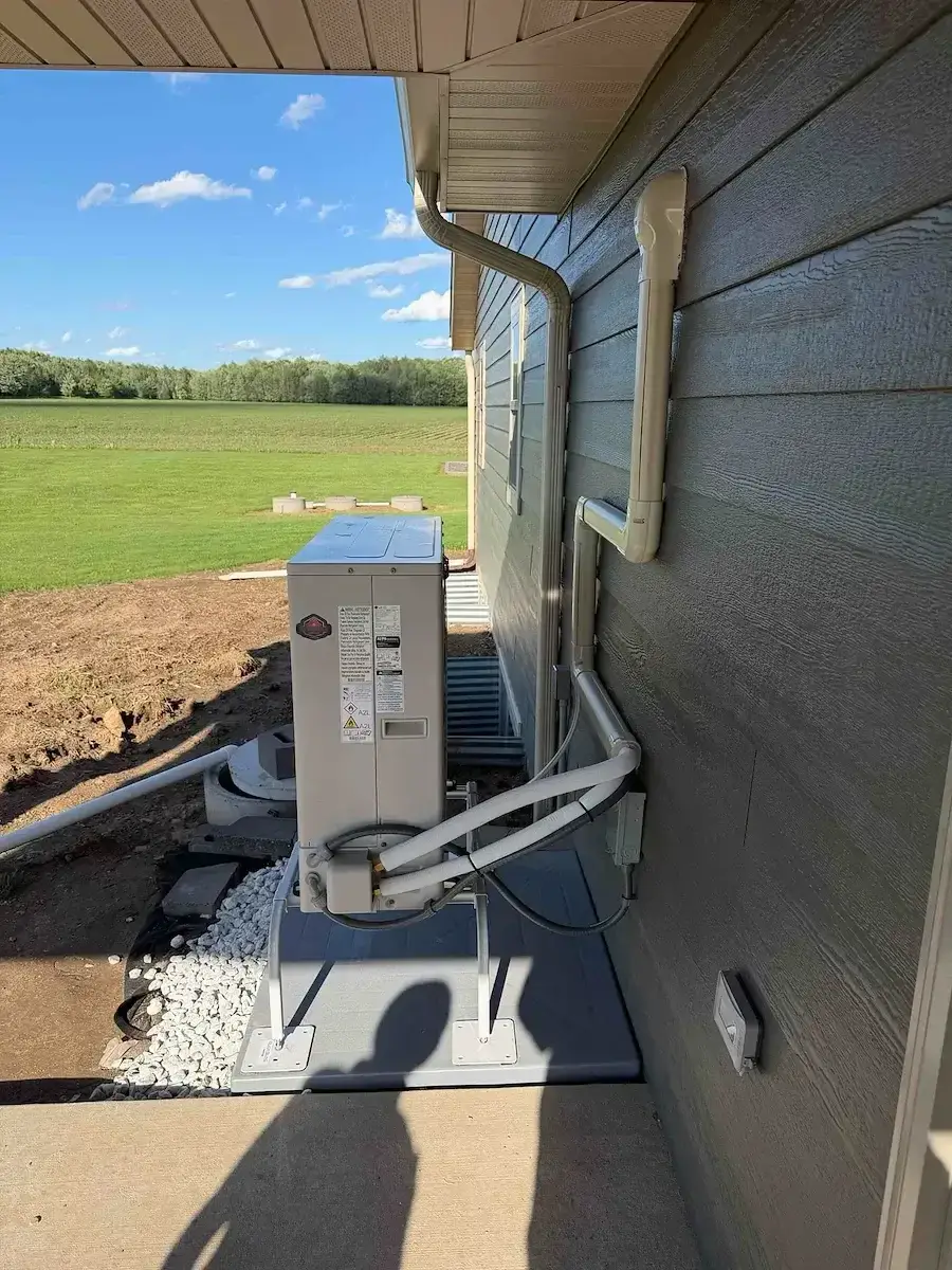 After — line set and condensate run tight to the wall in a paintable cover