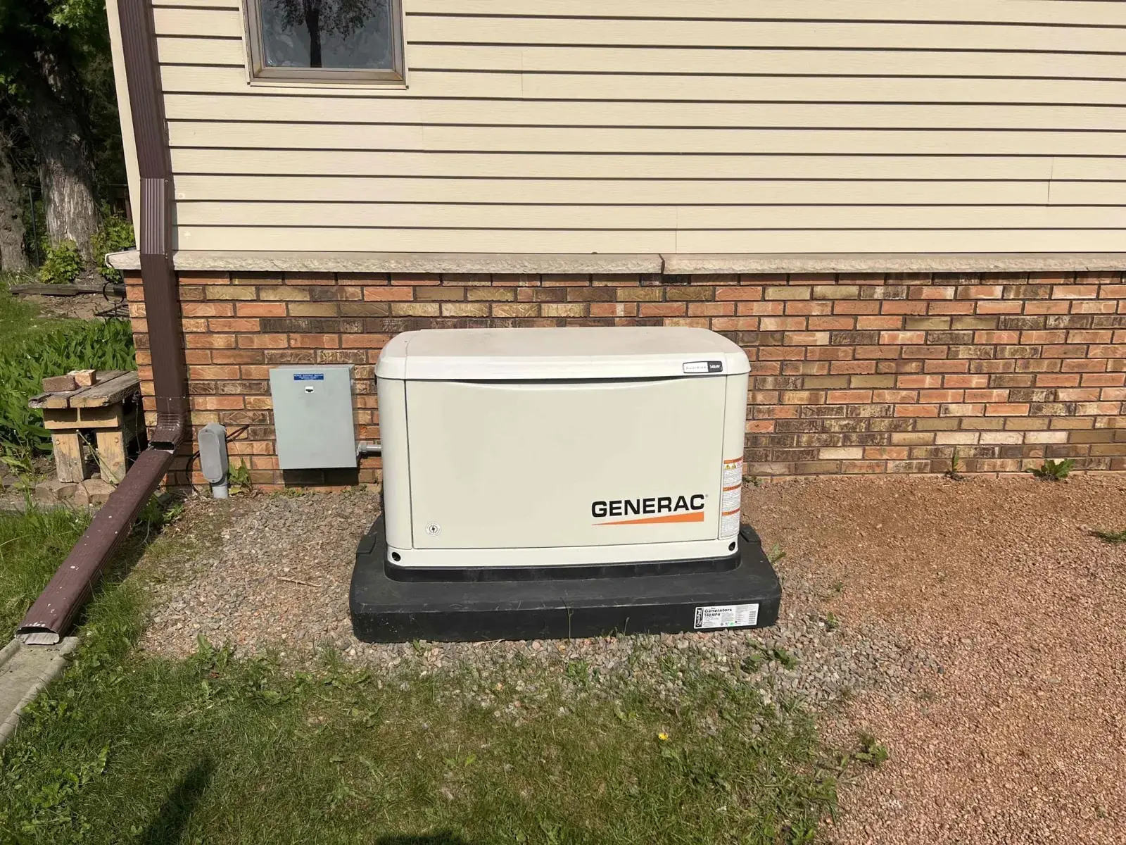 After — standby generator set on a composite pad beside the house