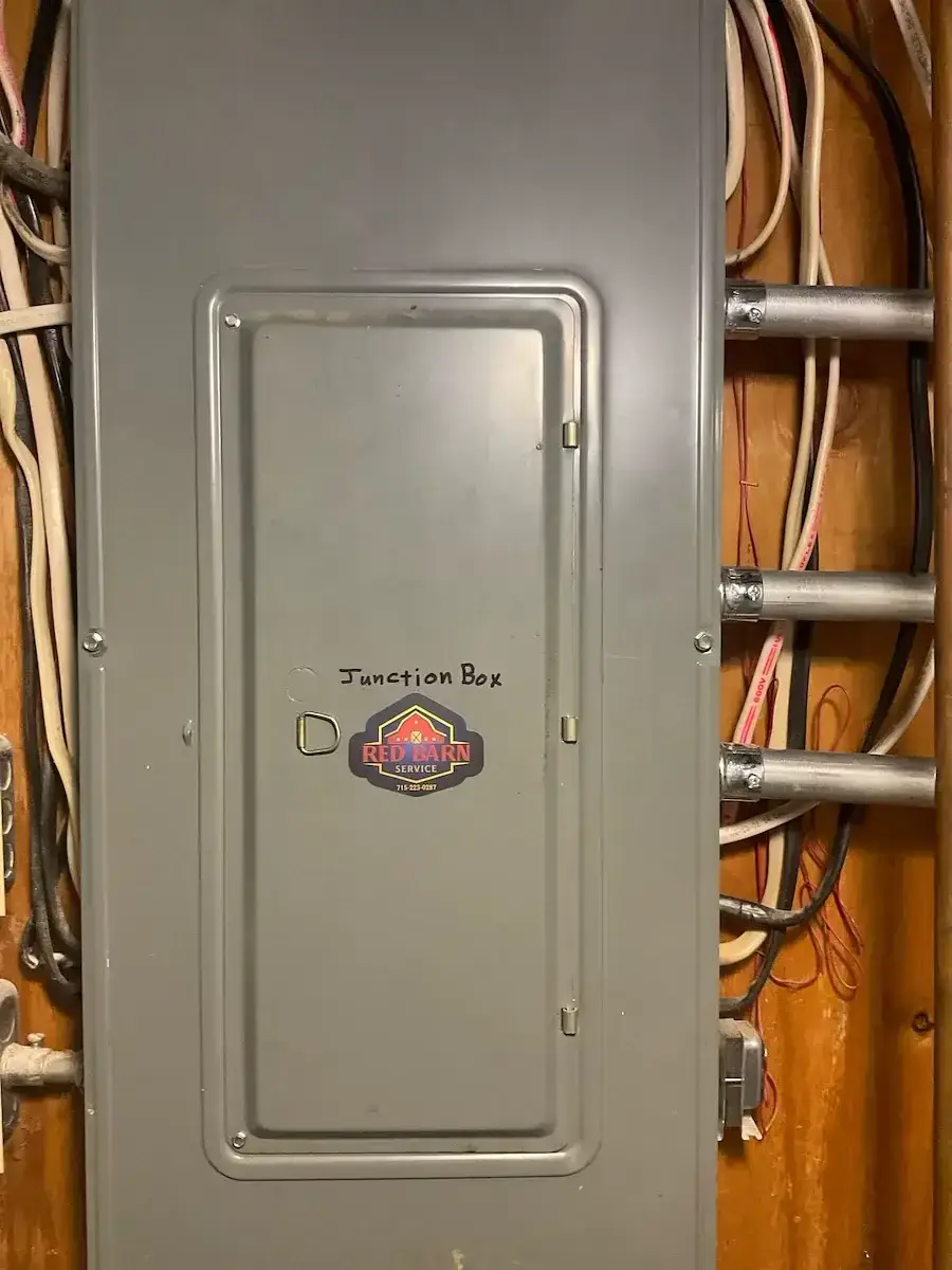 The same enclosure closed back up, labeled as a junction box and tagged with our sticker