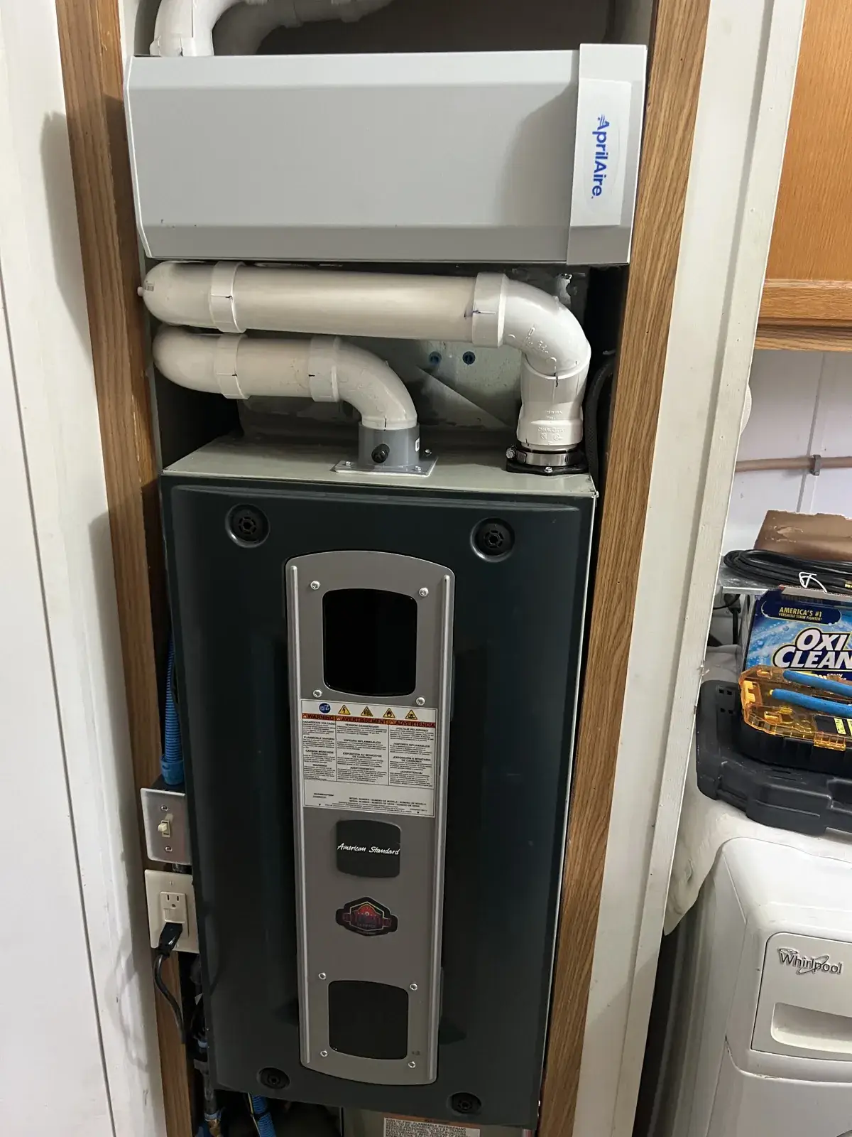 After — same mobile home closet from above: AprilAire filter cabinet mounted overhead with the new PVC venting