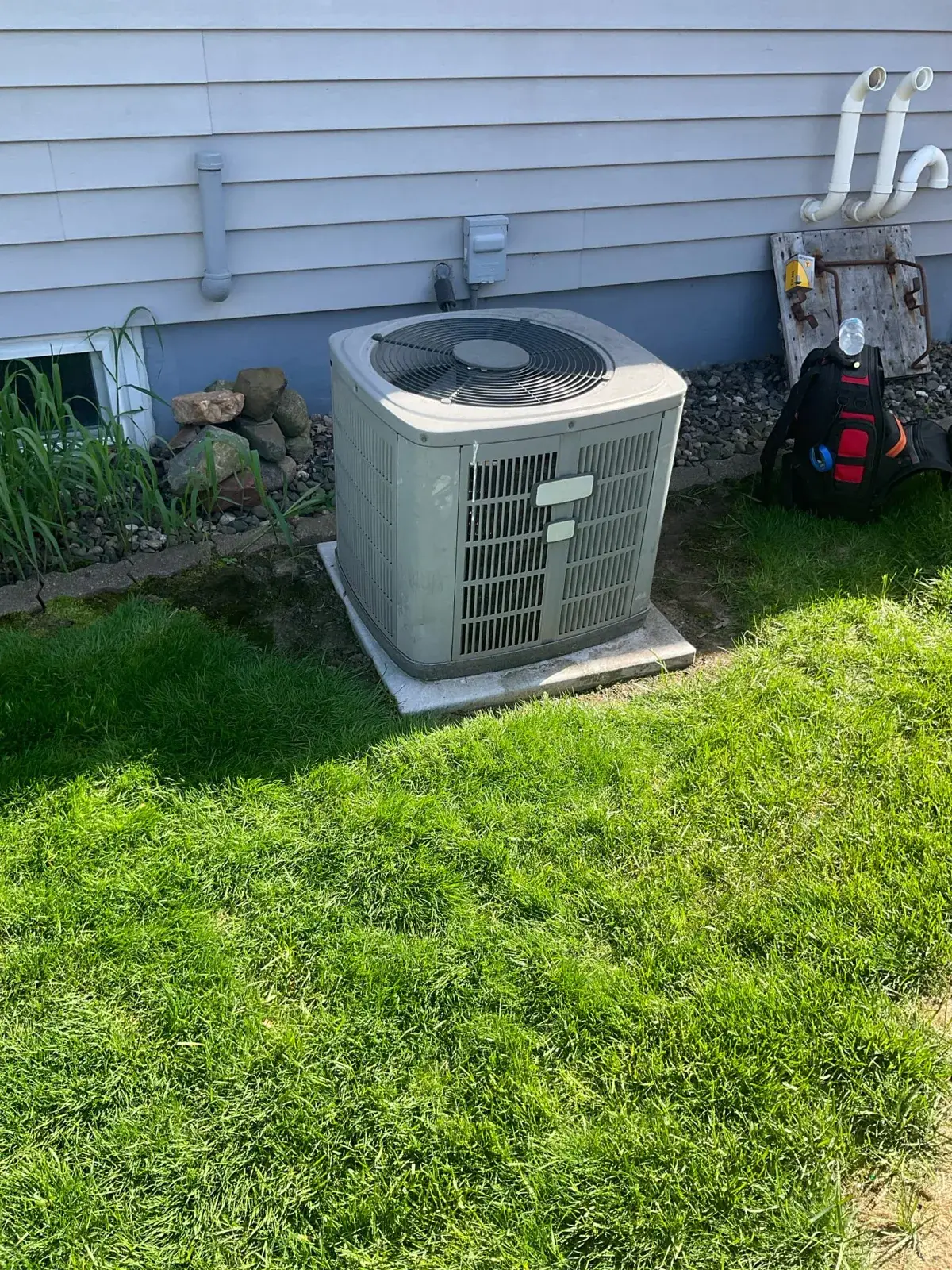 Before — an aging condenser sitting on a settled, cracked pad