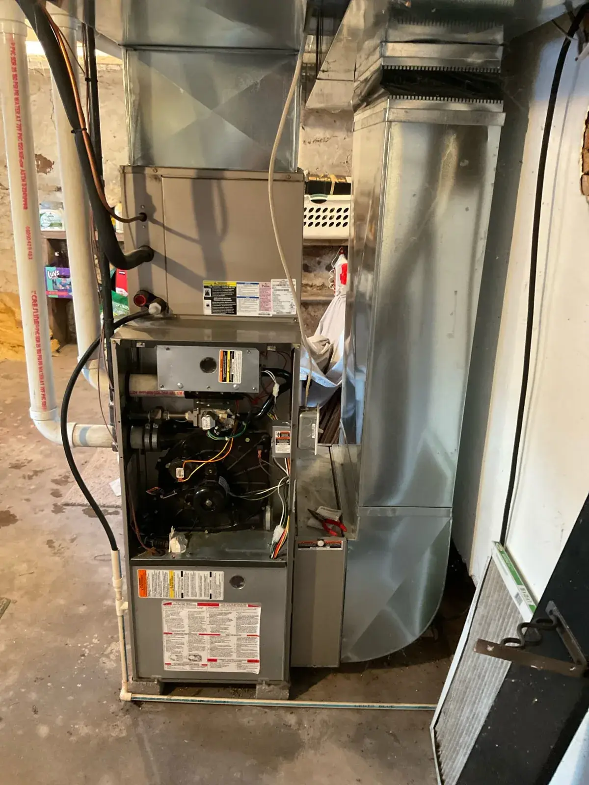 Before — the old furnace opened up, showing the aging burner and blower section